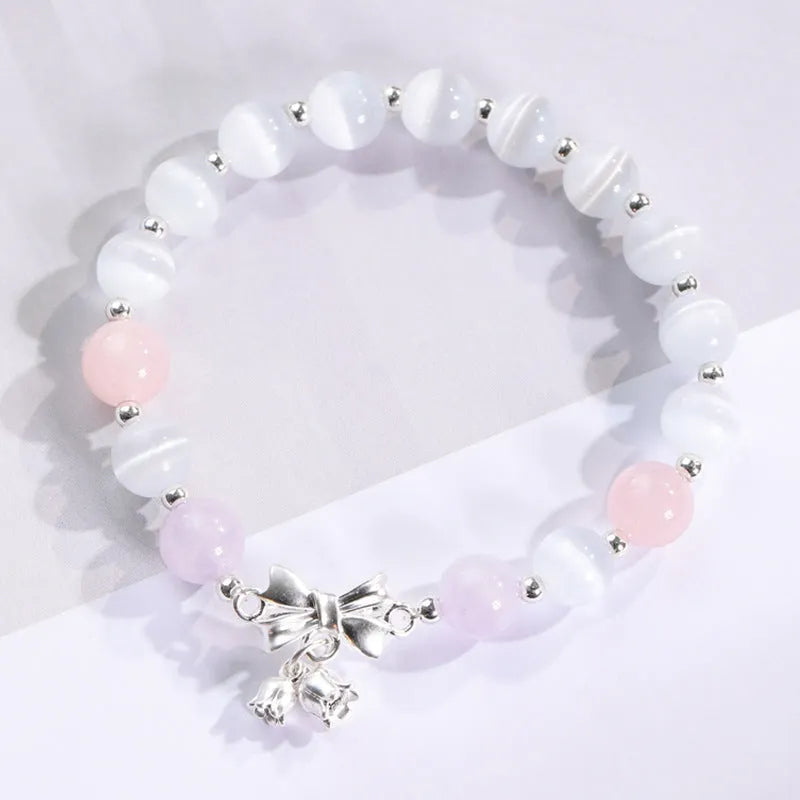 Close-up of a women's opal beaded bracelet with diamond-shaped cat's eye stones on a wrist.