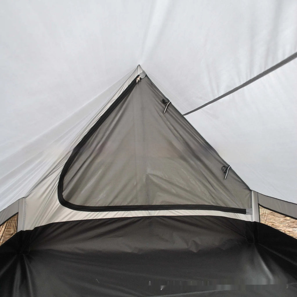 Brown ultralight A-frame hiking tent pitched with hiking poles in an outdoor setting