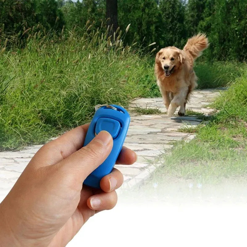 Pet training clicker and whistle set with key ring in orange, white, and blue plastic on a wooden table