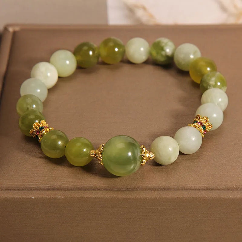 Xiuyan jade green women's bracelet with sweet Mori style design on a wrist.