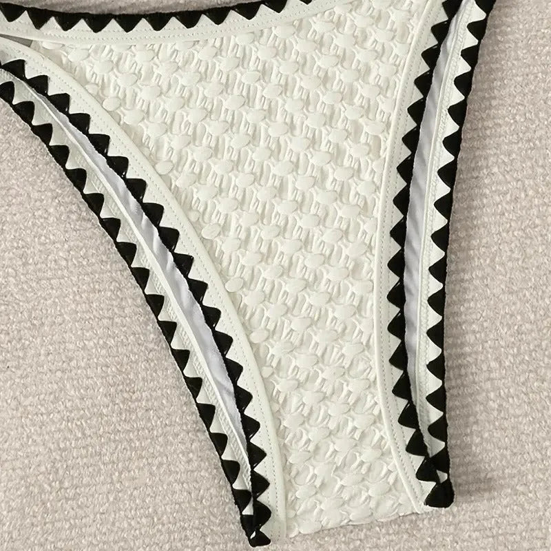 Women's blue and white polyester bikini swimsuit set with briefs style on hanger.