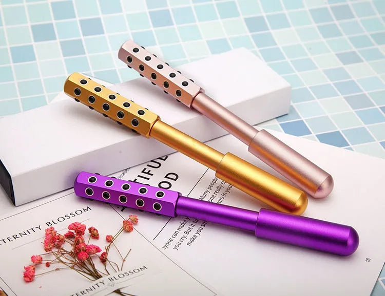 Purple handheld facial massage roller with germanium particles on a white background.