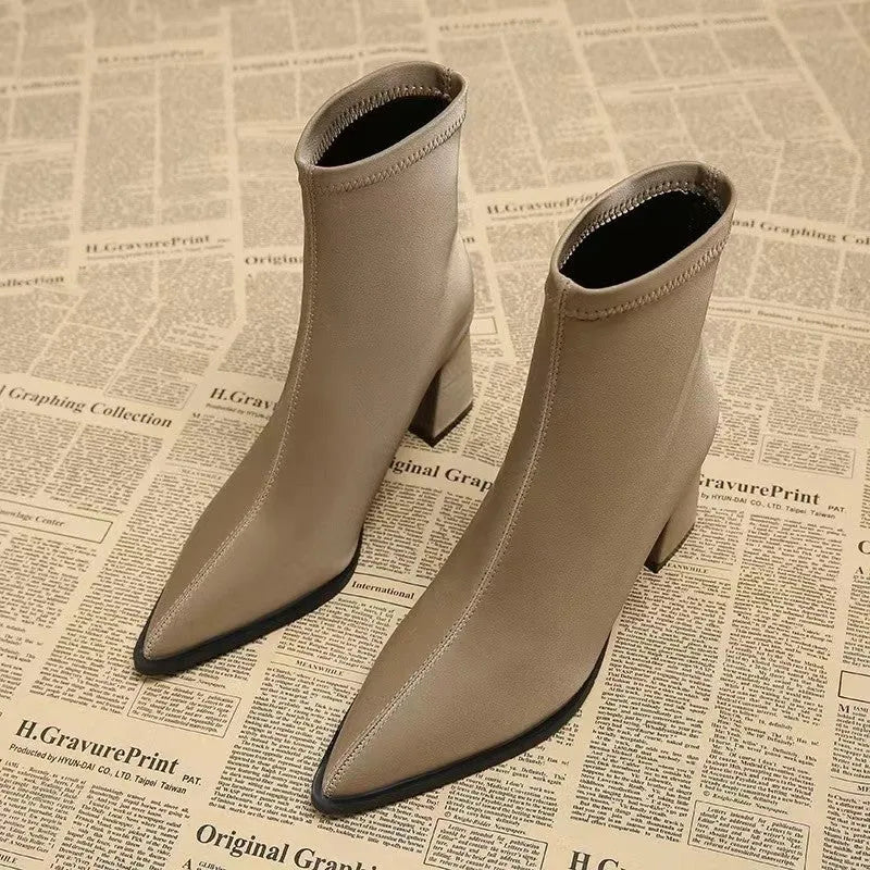 Women's khaki pointed toe Martin boots with a wedge heel on a rubber sole.