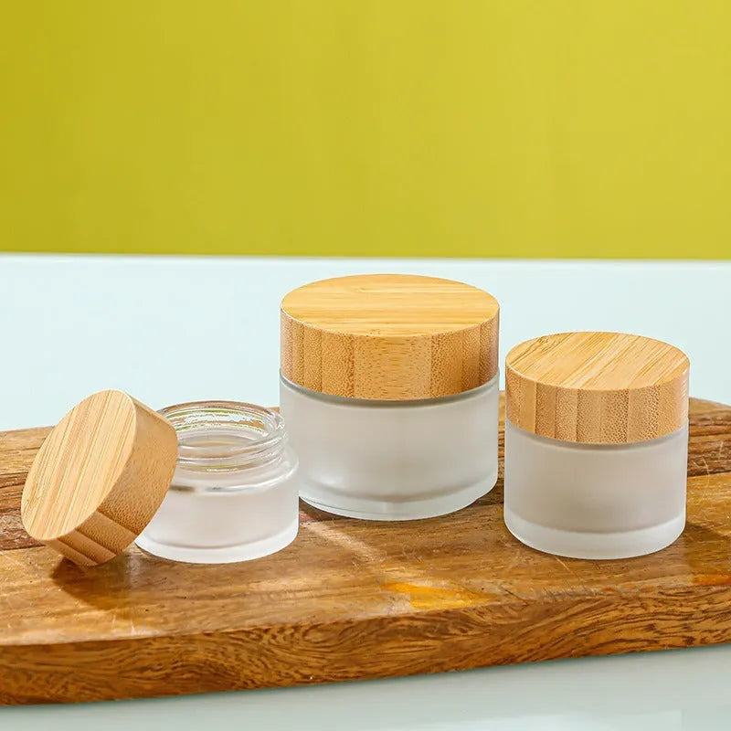 Glass cream jar with bamboo wood lid in frosted finish for facial skincare storage