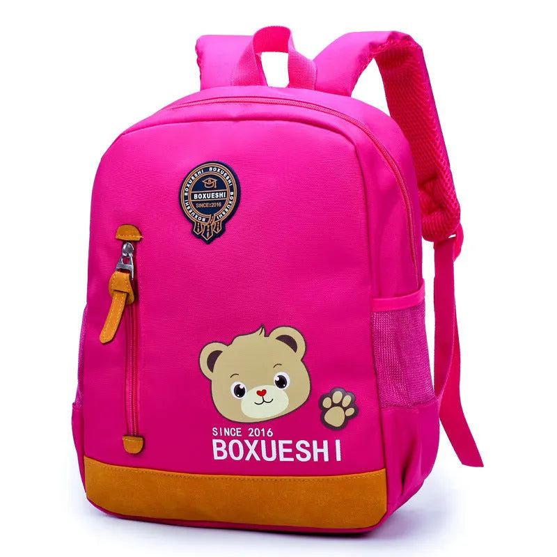Blue nursery backpack with a cartoon bear design, showing front zip pocket and adjustable padded straps.