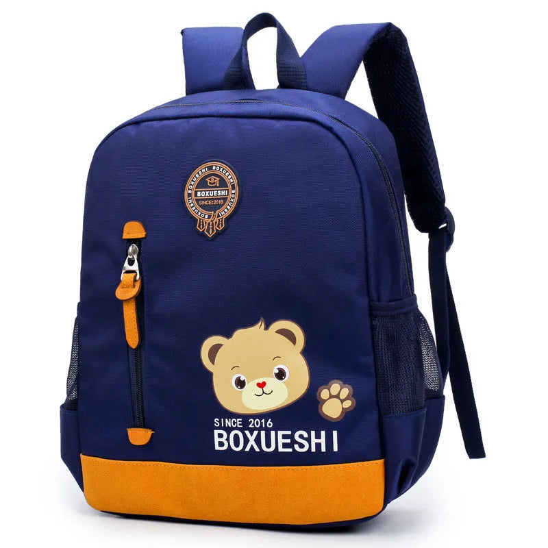 Blue nursery backpack with a cartoon bear design, showing front zip pocket and adjustable padded straps.