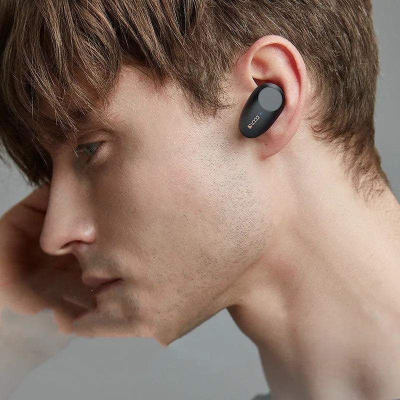 Black wireless Bluetooth headphones with charging stand showing true wireless stereo design