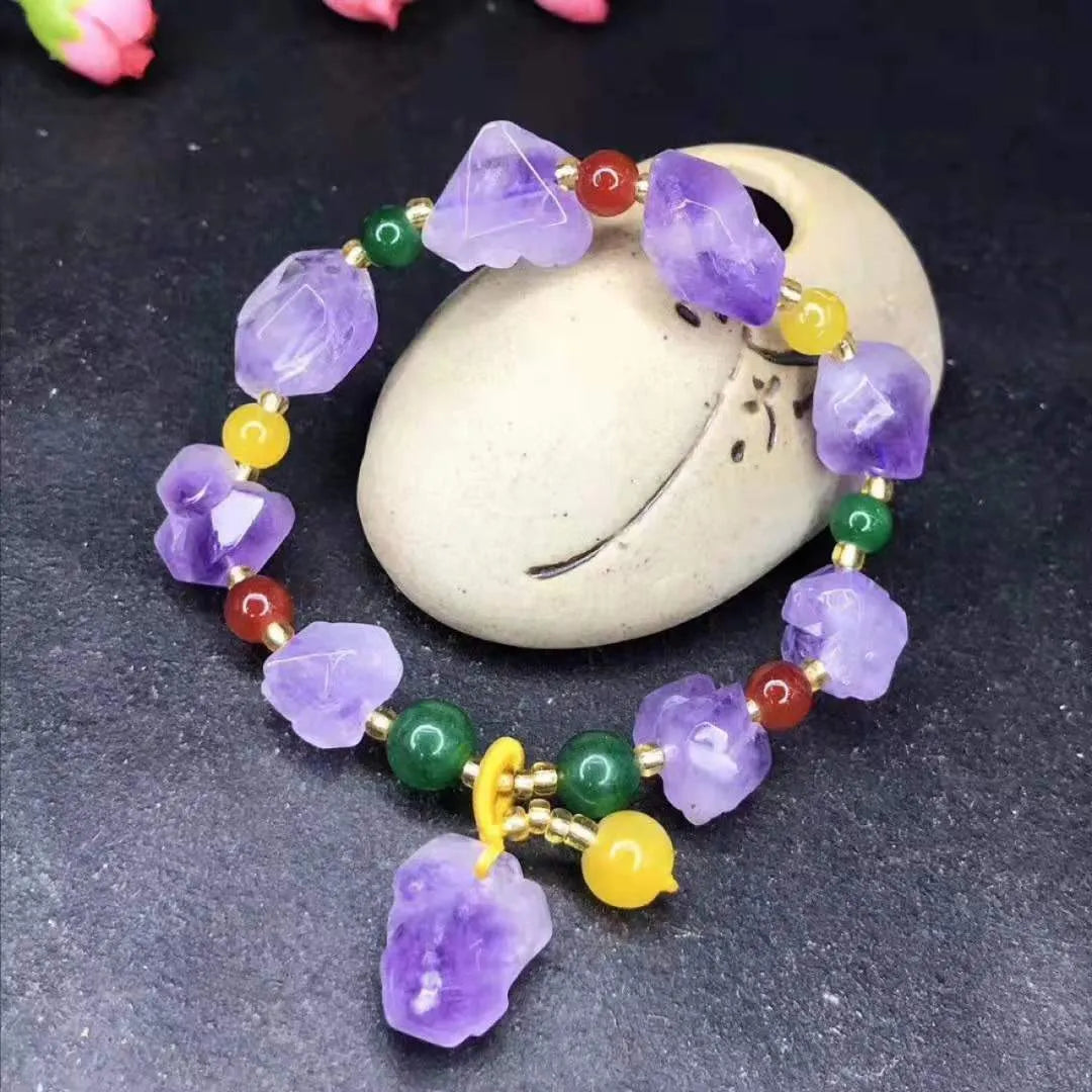 Women's amethyst bead bracelet with a Chinese fu character charm on a white background.