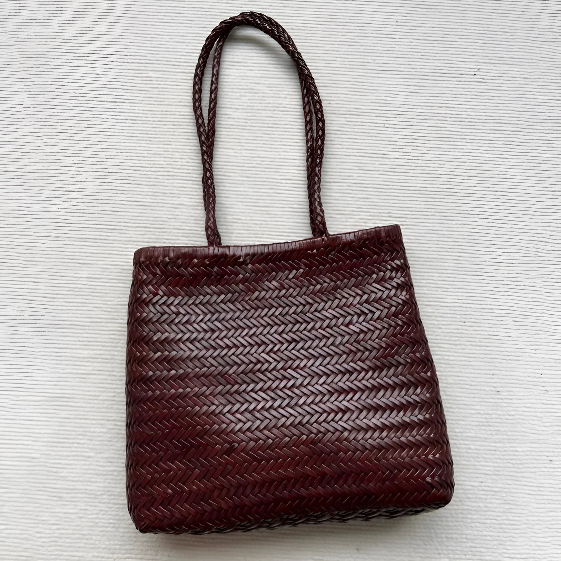 Handmade brown woven cowhide leather tote bag with a structured front pocket.
