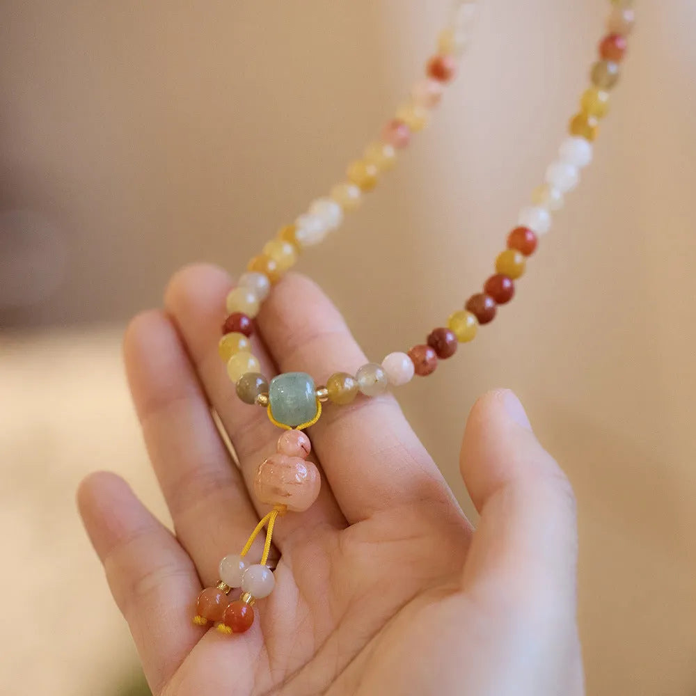 Women's green jinsi jade bracelet with golden threads and pumpkin tassel design