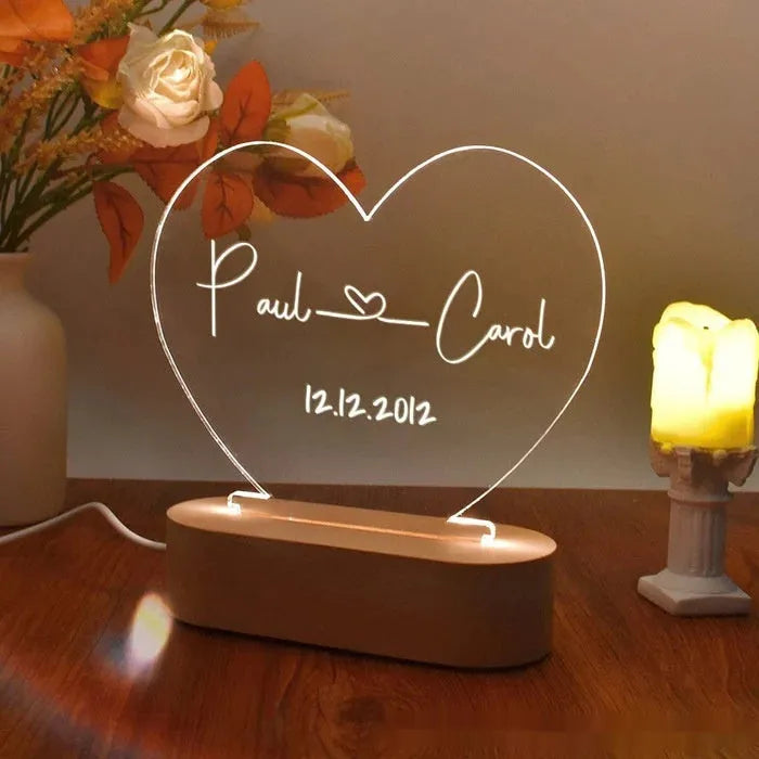 Custom acrylic night light with engraved names and date, lit by LED base.