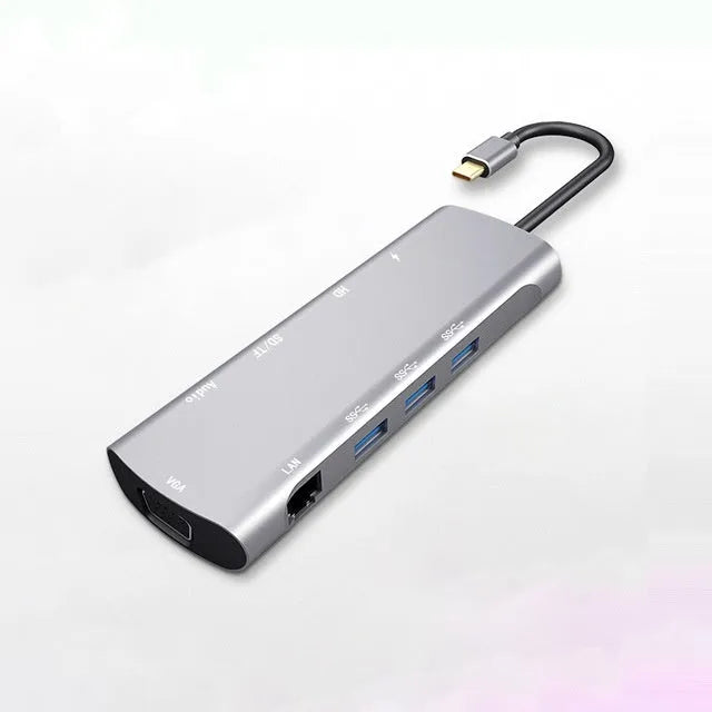 Grey aluminium USB-C docking station showing HDMI, VGA, USB 3.0, and card reader ports.