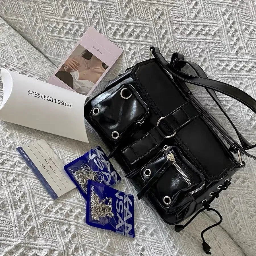 Black women's underarm baguette messenger bag with single shoulder strap showing interior zipper pocket