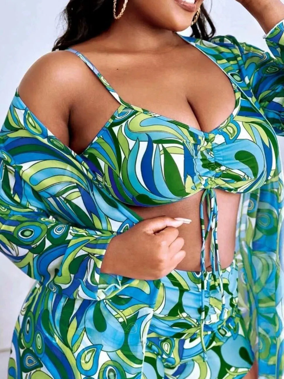 Women's floral print three-piece bikini set with cardigan on a mannequin.