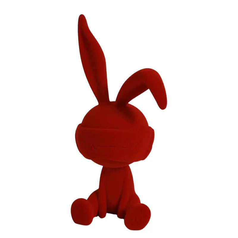 Green suede blindfold rabbit resin ornament seated on a table