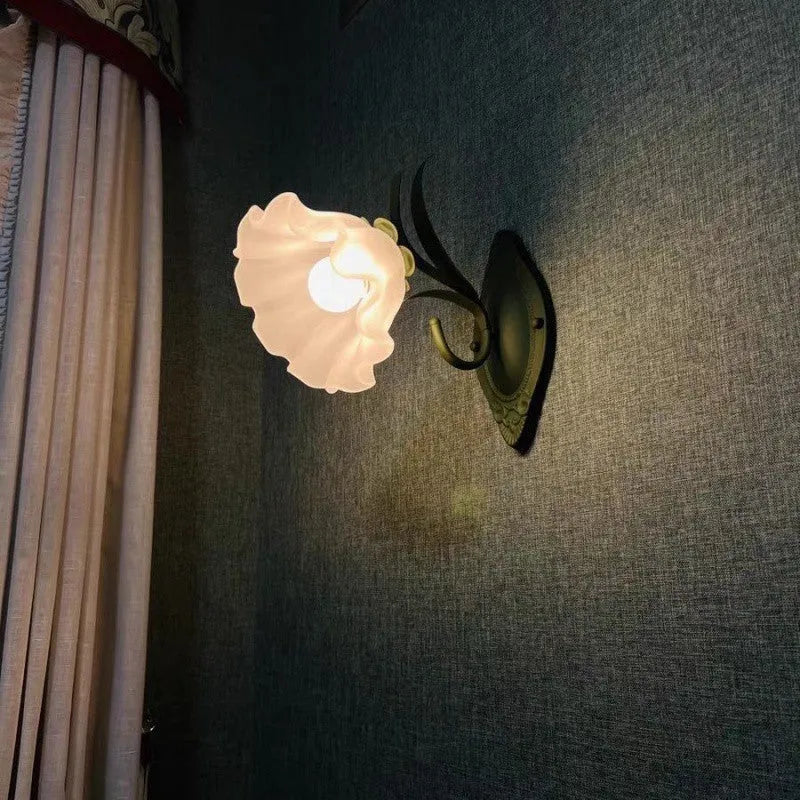 Green pastoral style flower-shaped wall lamp with a glass shade and integrated LED light.