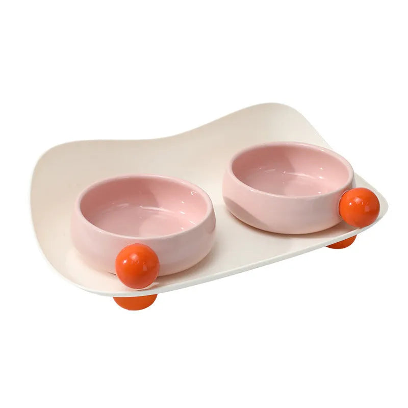 Ceramic pet feeding bowl set with two raised bowls and non-slip base in pink colour