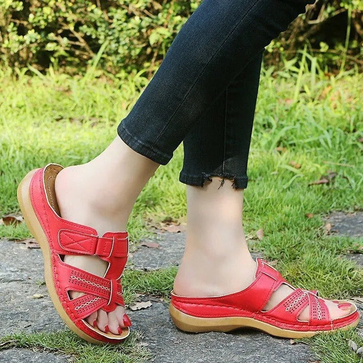 Women's red peep toe wedge sandals with a Velcro strap fastener on a white background.