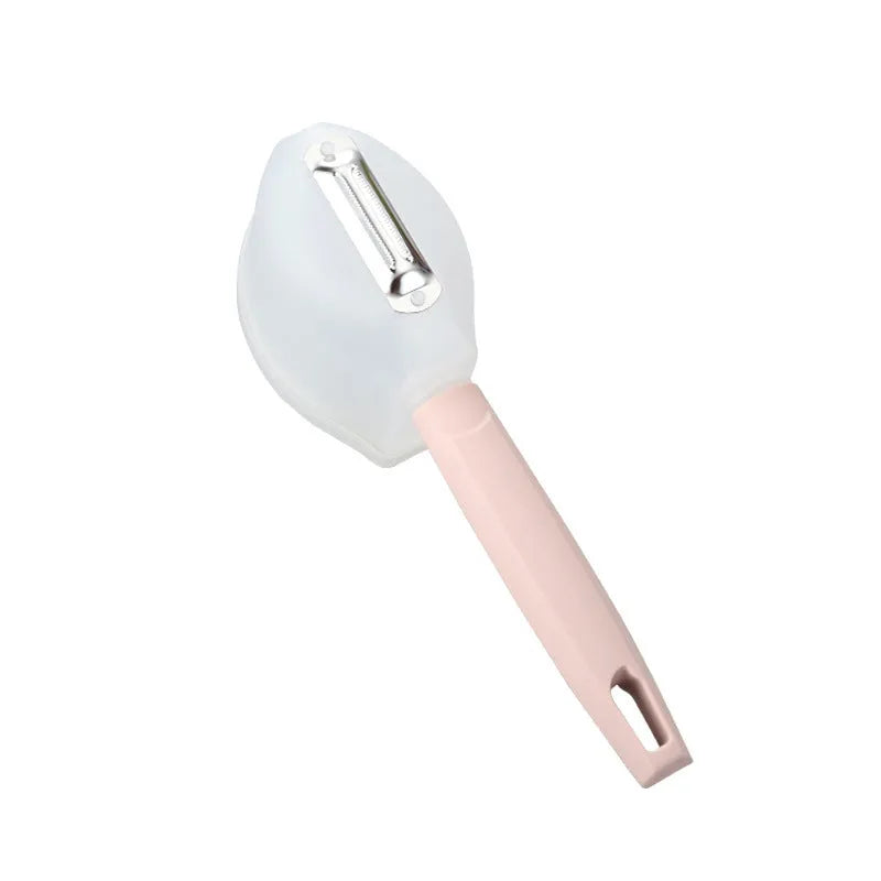 Stainless steel fruit peeler with pink plastic PP handle on light background