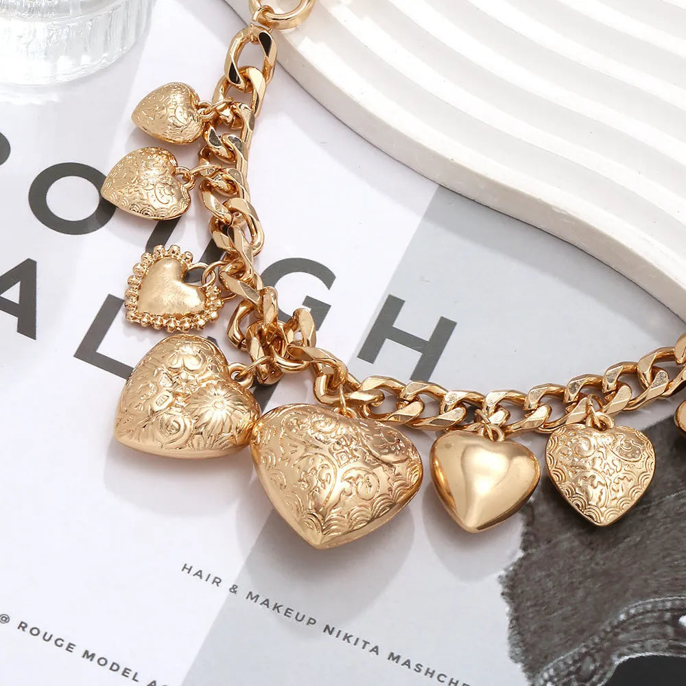 Exaggerated gold heart pendant necklace on a model, showing adjustable chain length.