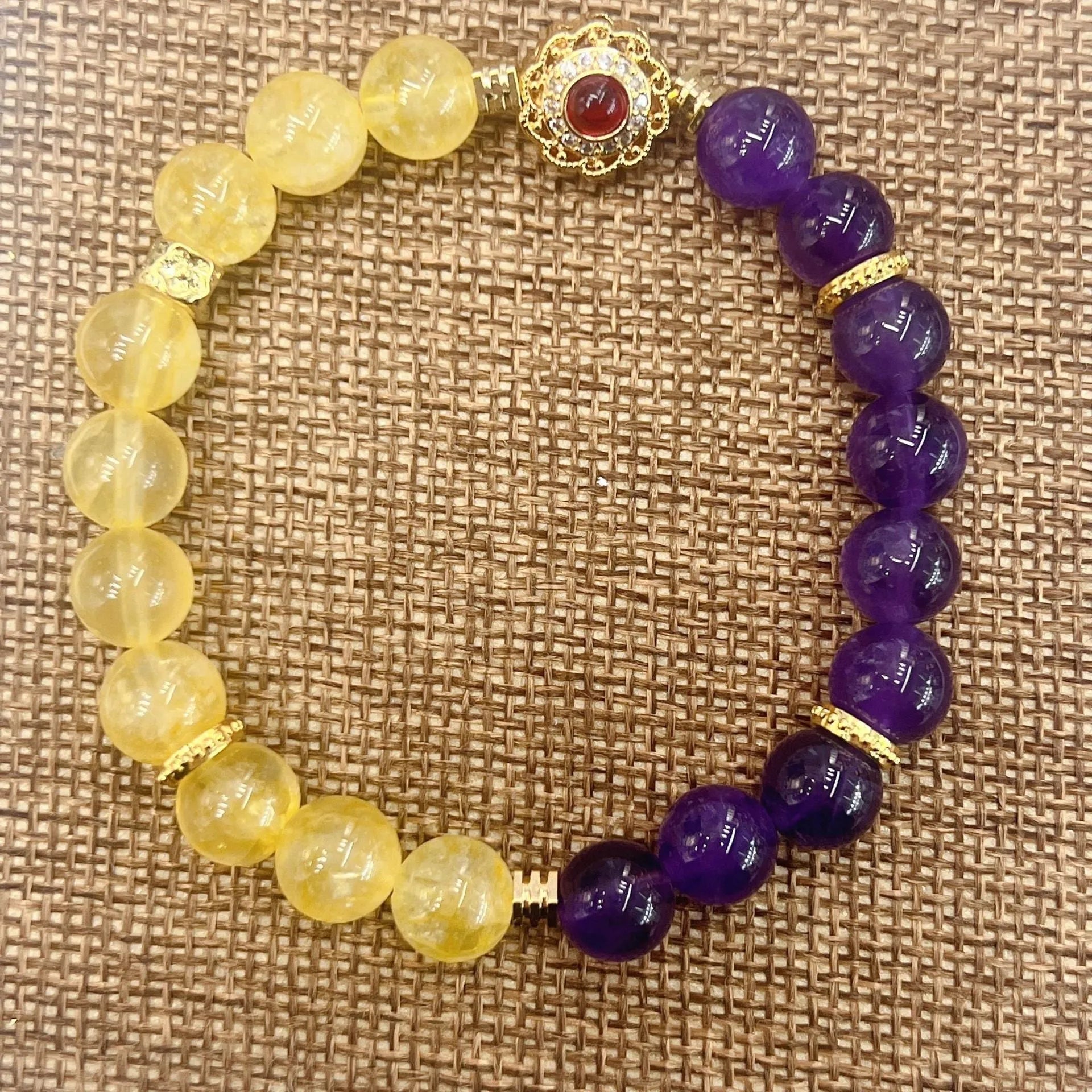 Handmade women's bracelet with yellow and purple amethyst crystals on wrist