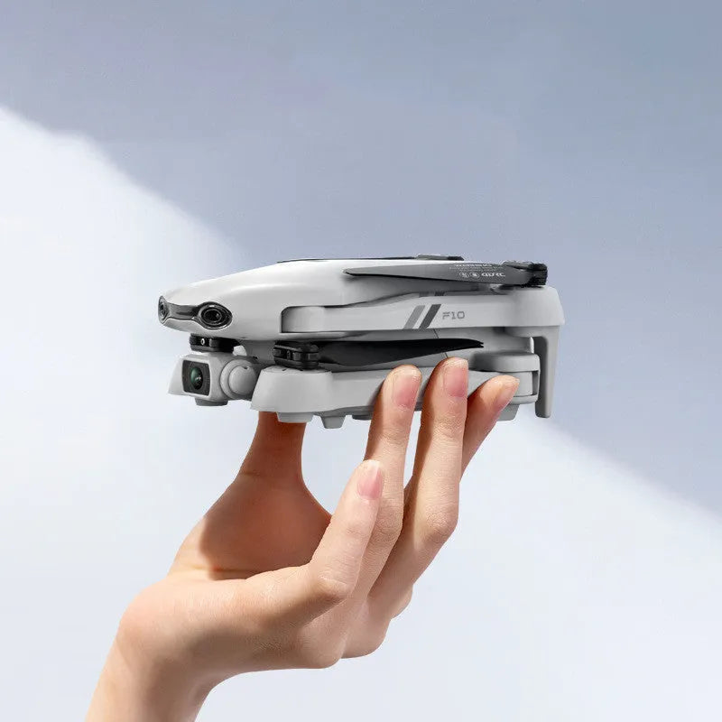 F10 folding GPS drone with 6K dual camera unfolded on a table showing propellers and camera