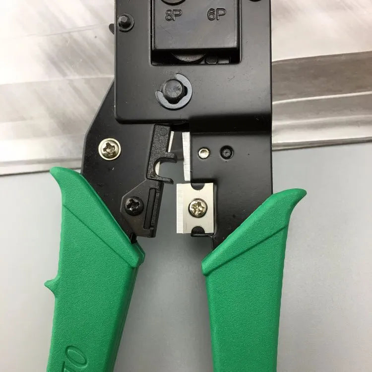 Green dual-purpose crystal head net pliers with tool steel jaws and plastic handle on plain background