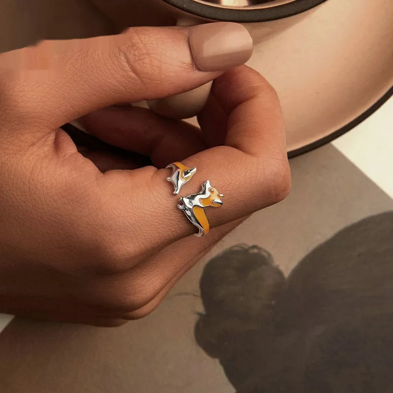 Silver ring with a raised cartoon corgi dog design on the band.