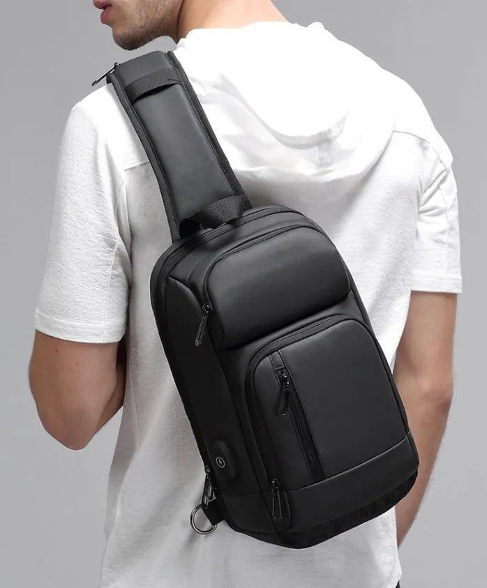 Black PVC outdoor leisure shoulder bag with a single strap, showing dedicated pockets for ID, phone, and computer.
