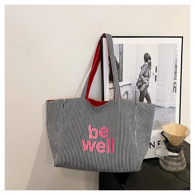 Large canvas tote bag with double straps and mobile phone pocket, 53x35x29cm, available in red, blue, and striped colours.