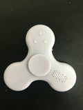 Square white Bluetooth speaker and fidget spinner toy with control buttons, measuring 80mm.