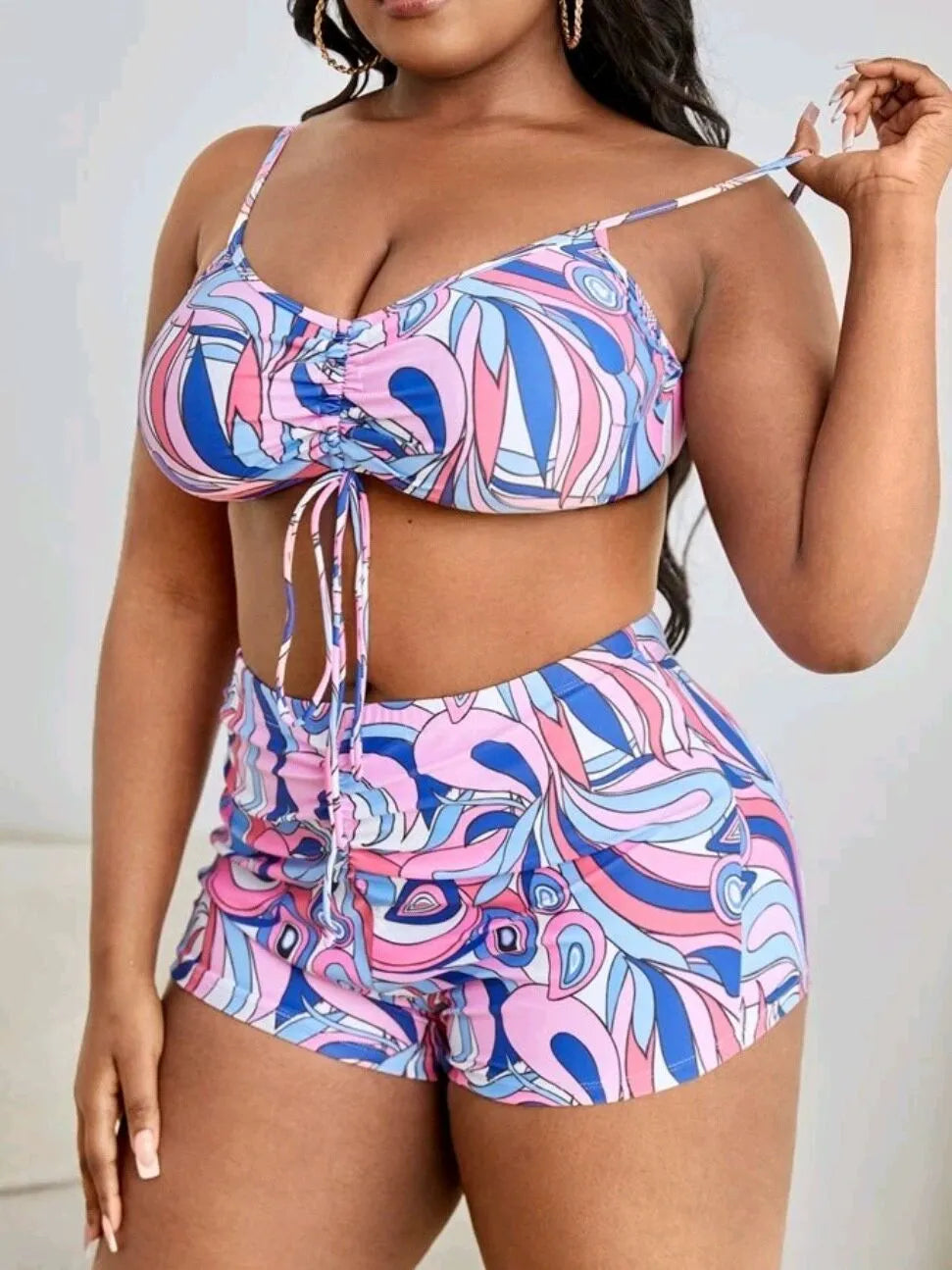 Women's floral print three-piece bikini set with cardigan on a mannequin.