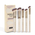 MAANGE apricot-coloured angled blush brush and four other makeup brushes on a table.