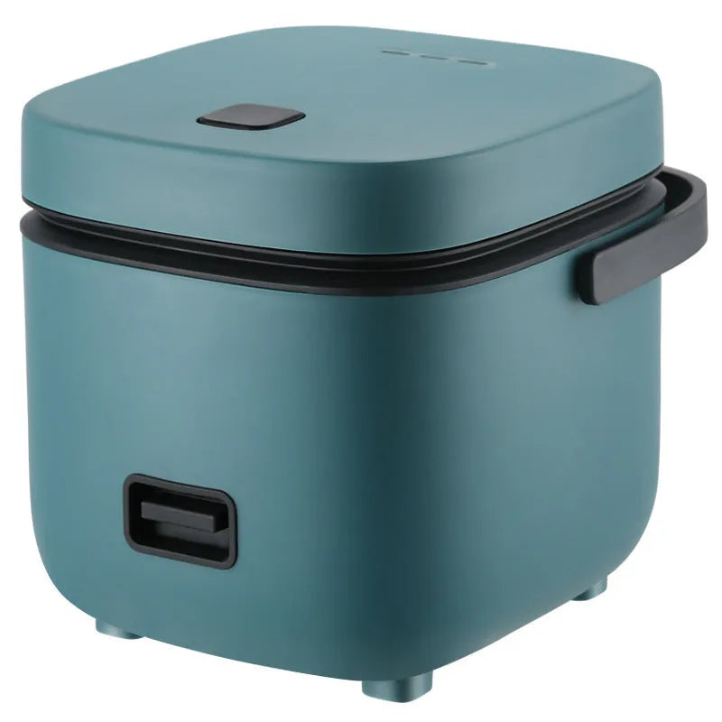 Green 1.2L mini rice cooker with metal body, button controls, and steaming plate on a worktop.