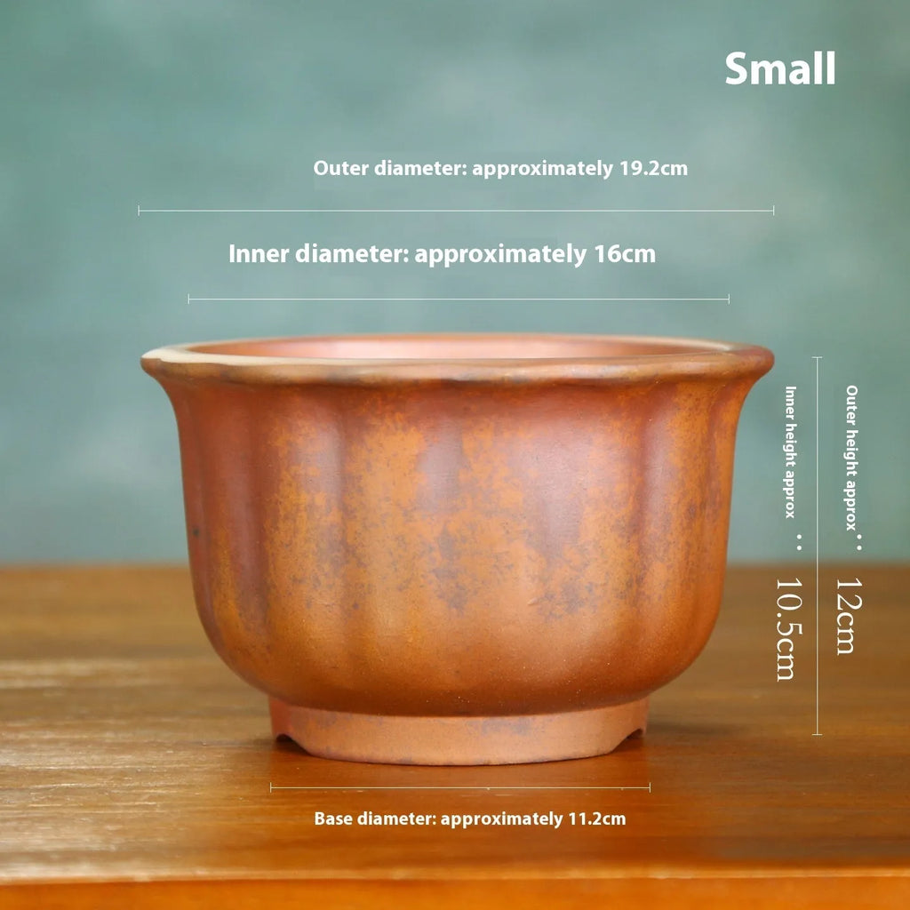 Indoor antique carved purple sand ceramic flowerpot for bonsai plants on a wooden surface.