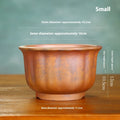 Indoor antique carved purple sand ceramic flowerpot for bonsai plants on a wooden surface.