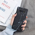 Samsung Galaxy phone in a PC case with a white and grey marble pattern on the back.
