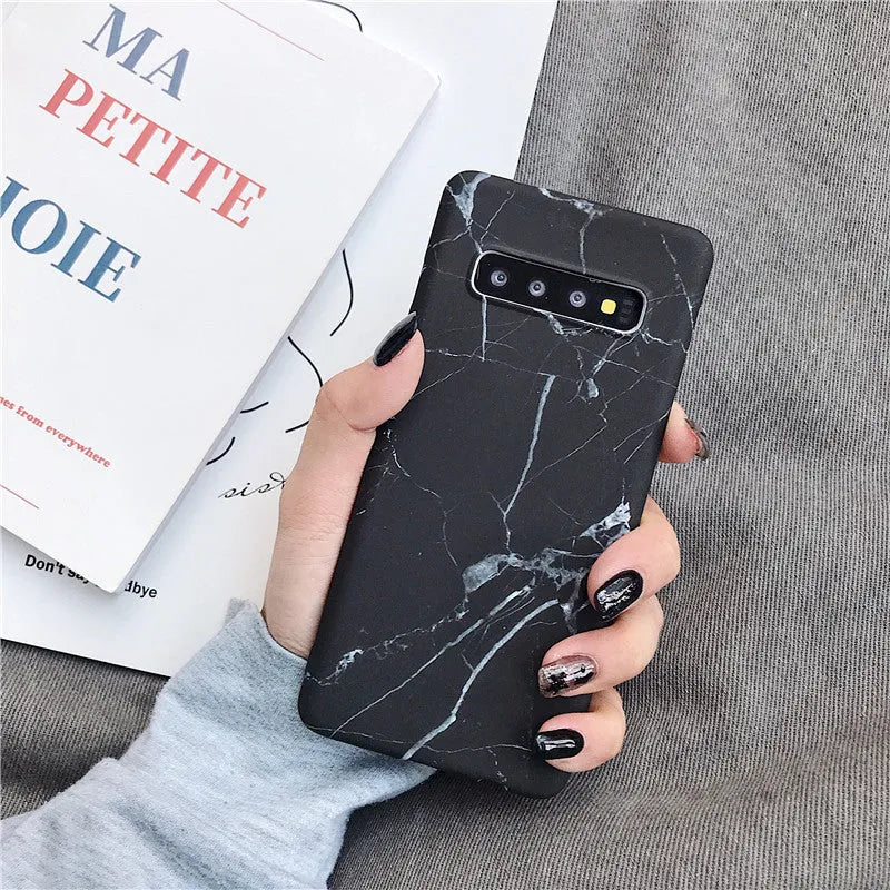Samsung Galaxy phone in a PC case with a white and grey marble pattern on the back.