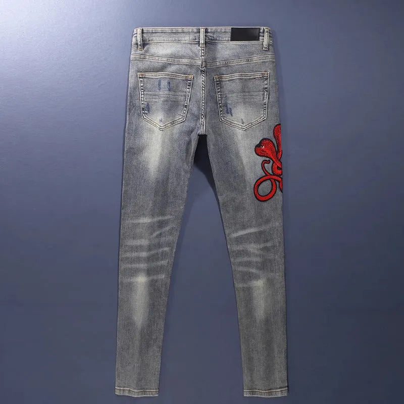 Men's slim fit jeans with embroidered patches and worn wash effect in old colour
