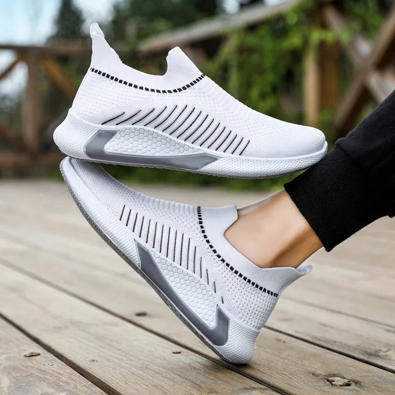 Men's black and white striped mesh slip-on sneakers with flyknit upper and low-cut profile.