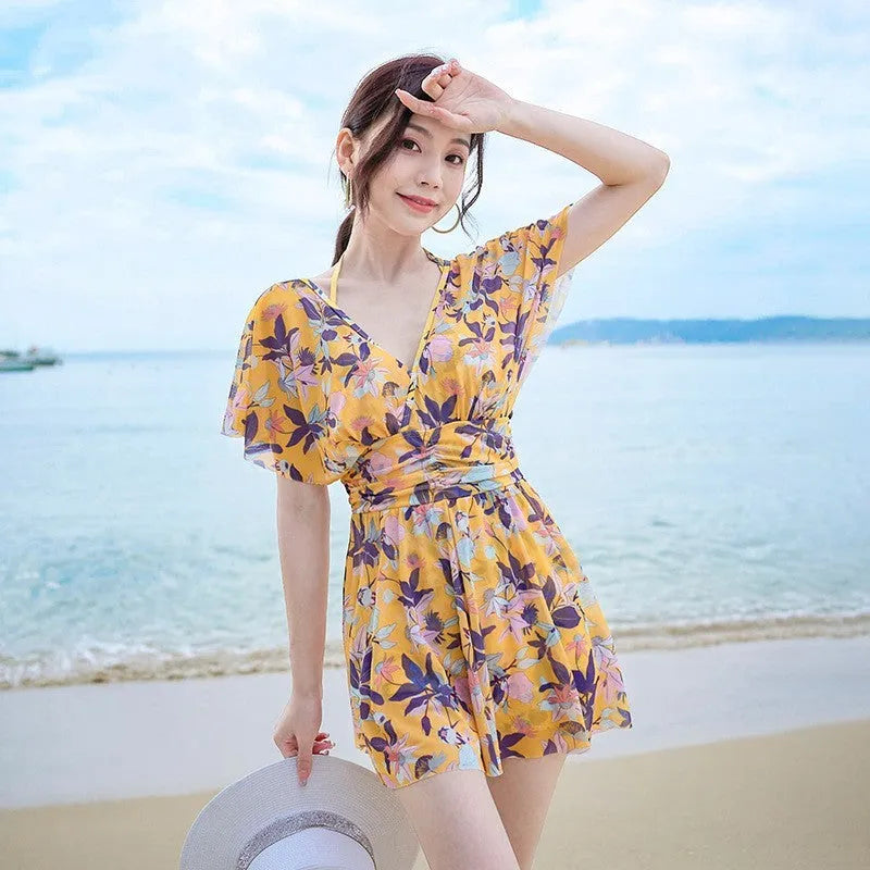 Yellow floral pattern women's one-piece swimsuit on a hanger showing front design