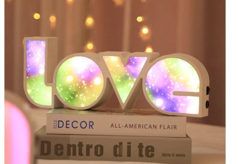 Rainbow style plastic LED decorative light spelling LOVE, shown on a table.