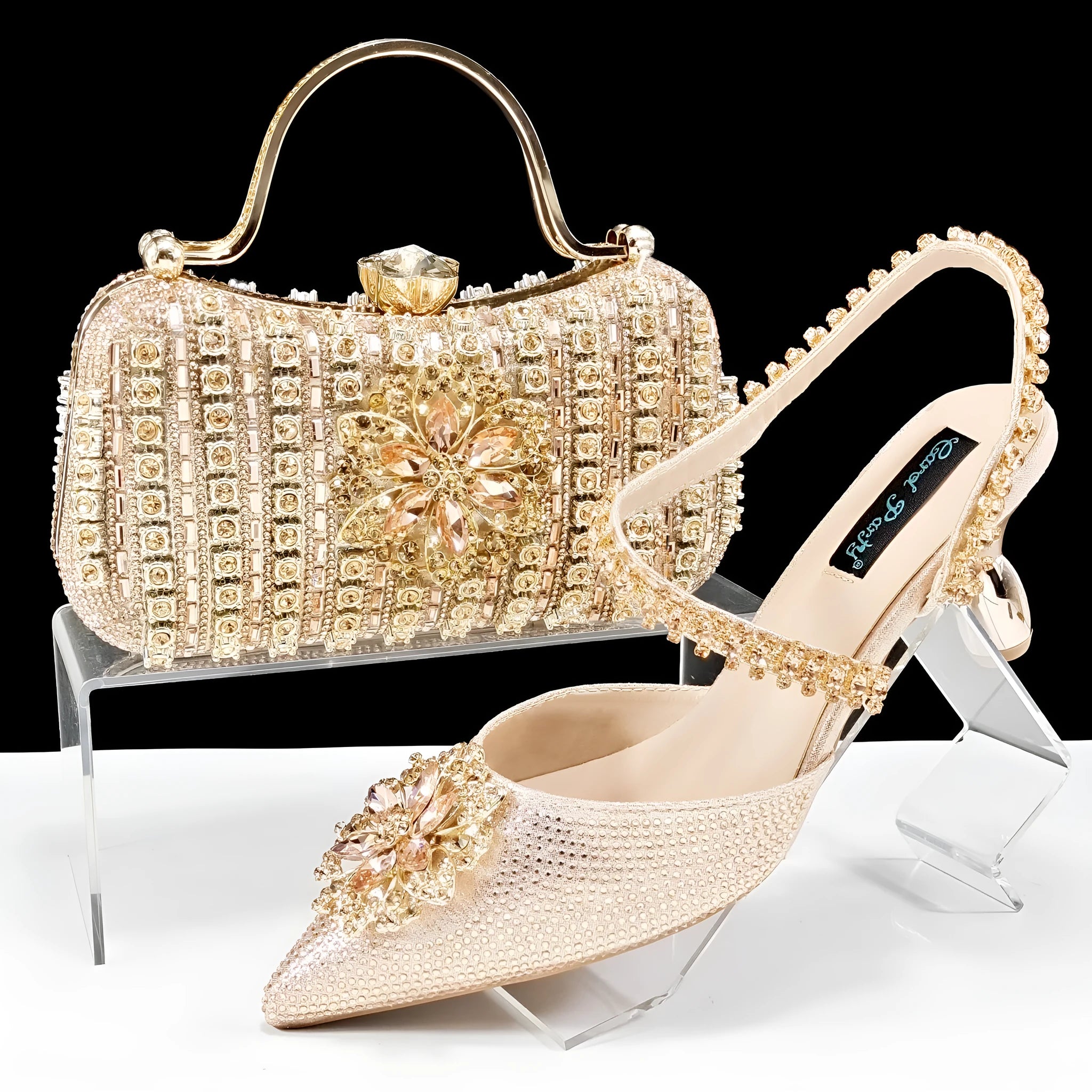 Women's black high-heel ankle strap sandal with rhinestone flower buckle and matching hard clutch bag.