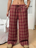 Women's blue plaid trousers with elastic drawstring waist and patch pockets laid flat