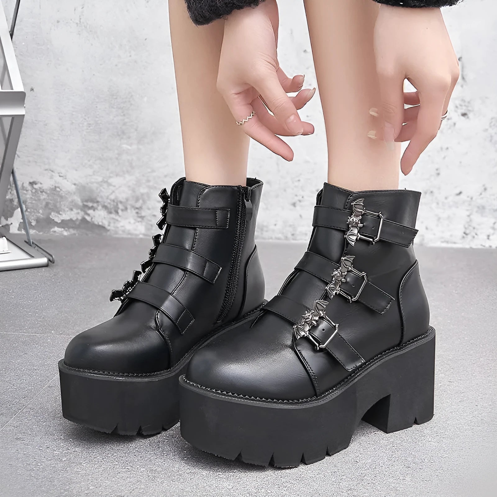 Black women's punk gothic Martin boots with bat buckle detail and side zipper.