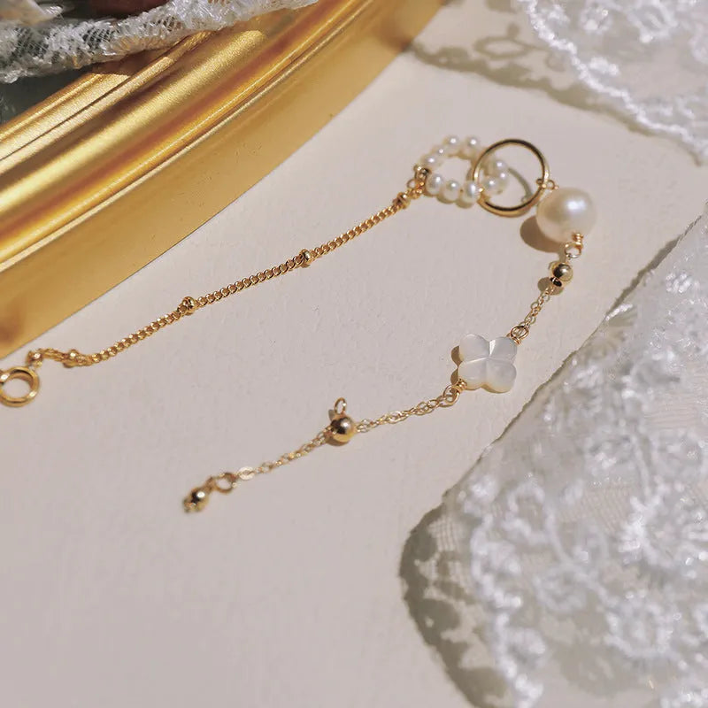 Close-up of a women's natural pearl bracelet with 14k gold-plated metal detailing.