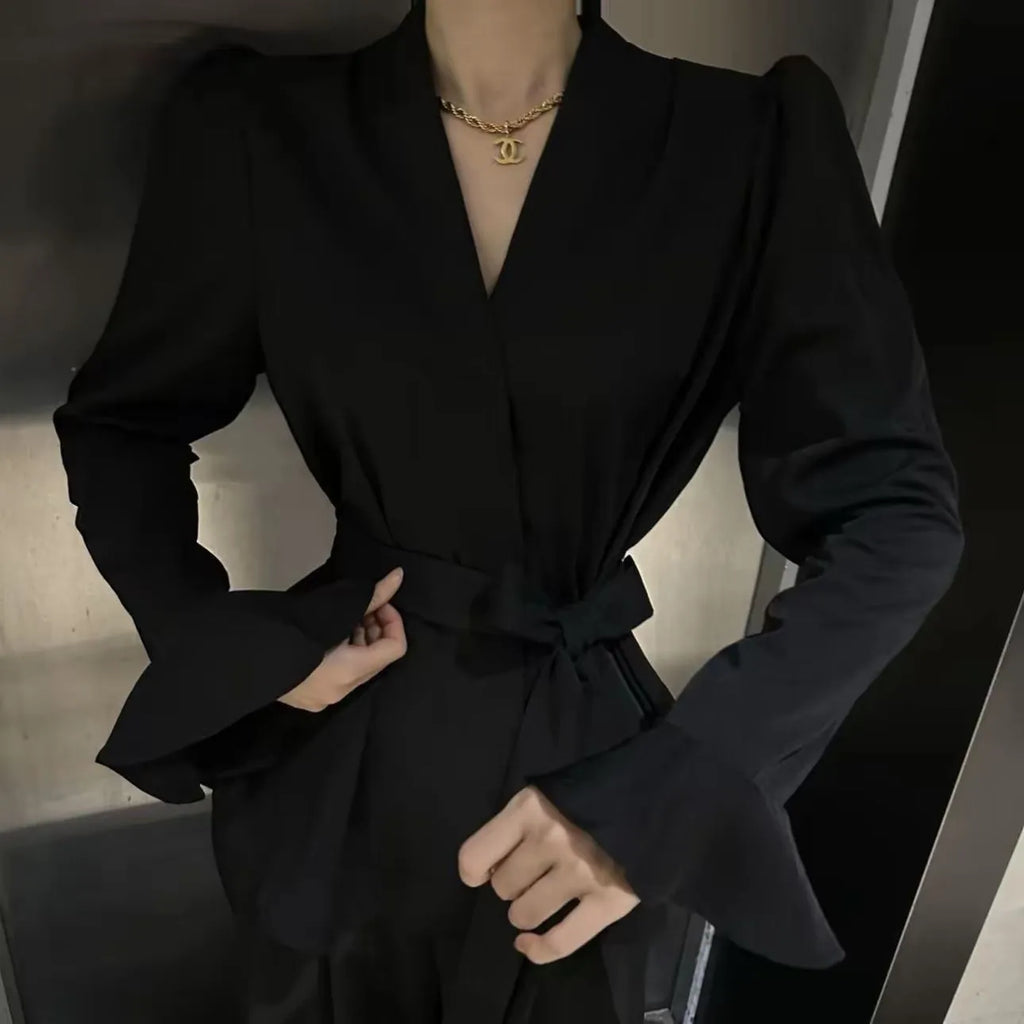 Women's black French-style shirt with long bell sleeves, an irregular collar, and a tied front detail.