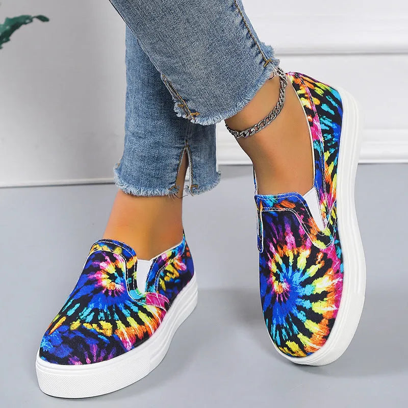 Women's low-top canvas slip-on sneaker in multiple colours, showing flat rubber sole and slip-on design.