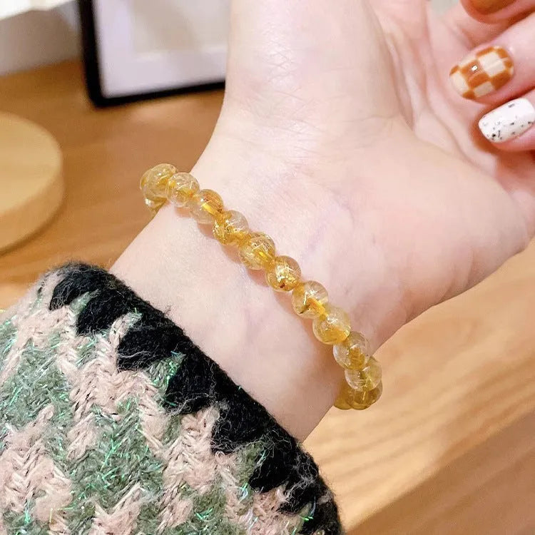 Women's gold rutilated quartz sunstone crystal bracelet with diamond-shaped and round beads