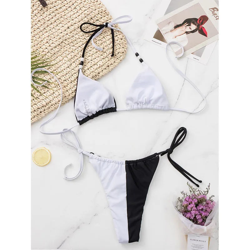 Black and white women's bikini set with lace-up front on triangle top and matching briefs.